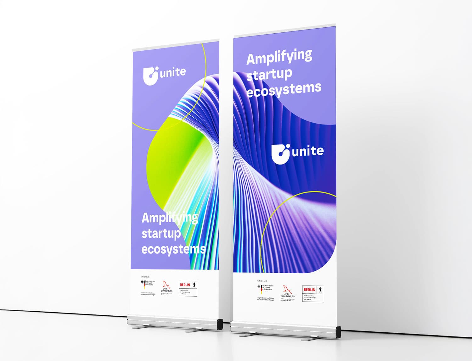 Mock-up mit 2 Roll-Ups, die im Corporate Design von Unite gestaltet wurden. Das Lamellenmotiv auf lila Hintergrund geht über beide Flächen und ergibt ein Gesamtmotiv. Unten weißer Sockel mit diversen Logos.